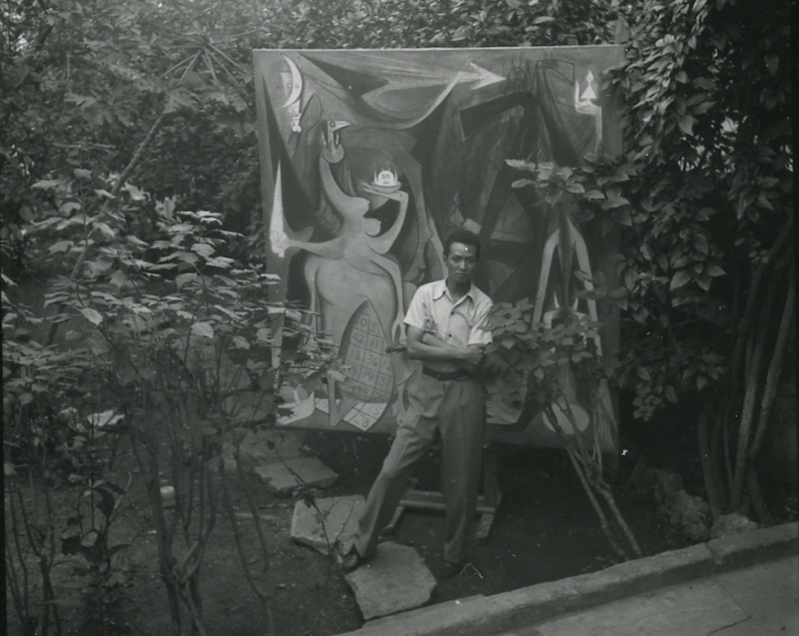 Wifredo Lam con la pintura Bélial en su jardín en La Habana (1947). Foto tomada de la página del MoMA.