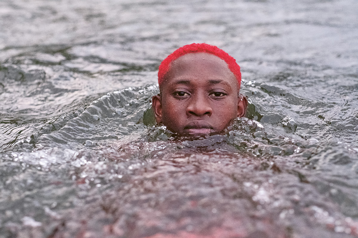 Camilo García Valencia, de dieciocho años, se baña en las aguas claras del río Yurumanguí, a ocho horas en lancha de Buenaventura, Valle del Cauca. Varios jóvenes acuden al río al caer la tarde durante el fin de las festividades tradicionales de Manacillos, que se celebran en Semana Santa en la vereda Juntas. Según los mayores de la comunidad, solo al final de estas festividades únicas y ancestrales los junteños pueden bañarse en el río, marcando así el retorno a la normalidad —el trabajo en las minas— y la despedida de los matachines, el principal personaje de estas celebraciones. Foto de Marina Sardiña.