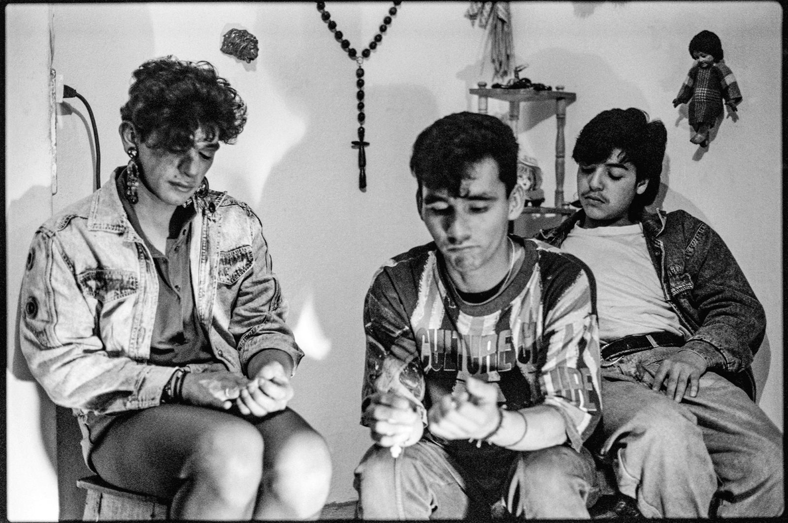 Foto-fija de Alberto Sierra para el documental El cumpleaños de Sprite (título no definitivo), un proyecto inédito grabado en Bogotá entre 1991 y 1992, centrado en la prostitución masculina de jóvenes —algunos menores de edad— que trabajaban en la carrera Séptima con calle 24, frente al centro comercial Terraza Pasteur. El grupo retratado vivía en una casa del barrio Egipto, bajo el cuidado de una mujer mayor que los acogía como una figura materna en la ciudad. Los adoraba. En la primera imagen aparece «La Pinocha», el mayor del grupo, con veintitrés años. En la segunda, «La Pinocha» comparte el encuadre con «Jennifer» y «El Llanero».