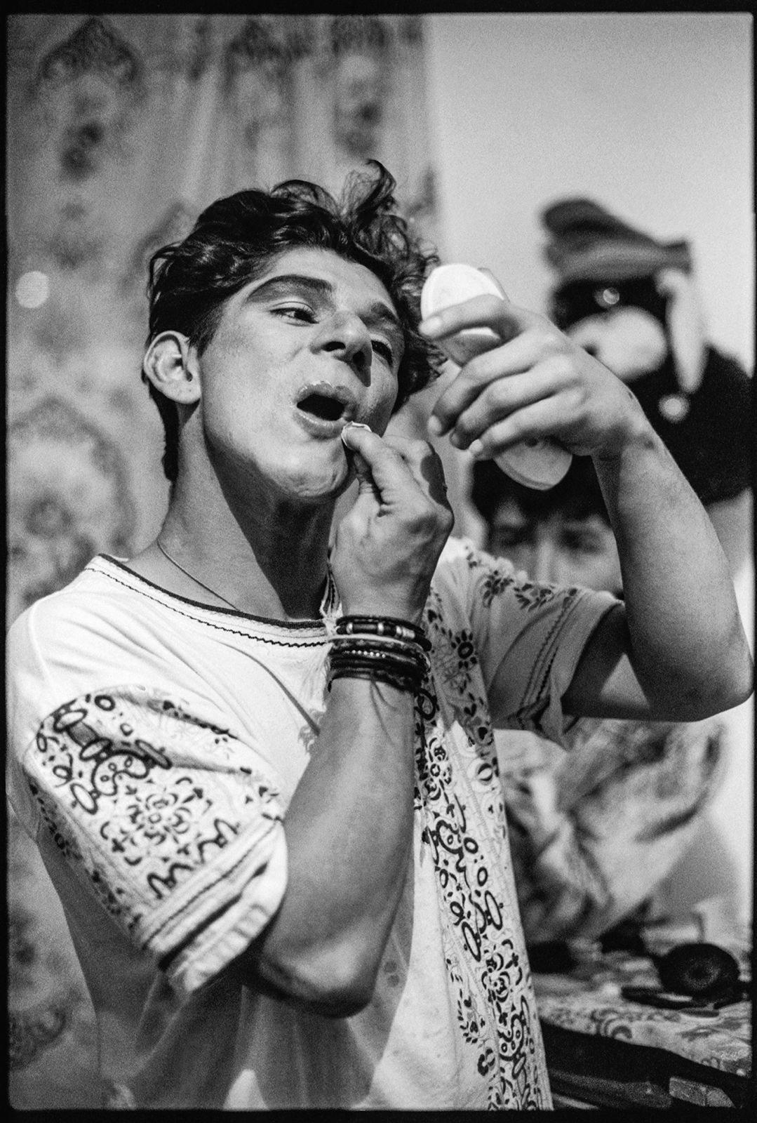 Foto-fija de Alberto Sierra para el documental El cumpleaños de Sprite (título no definitivo), un proyecto inédito grabado en Bogotá entre 1991 y 1992, centrado en la prostitución masculina de jóvenes —algunos menores de edad— que trabajaban en la carrera Séptima con calle 24, frente al centro comercial Terraza Pasteur. El grupo retratado vivía en una casa del barrio Egipto, bajo el cuidado de una mujer mayor que los acogía como una figura materna en la ciudad. Los adoraba. En la primera imagen aparece «La Pinocha», el mayor del grupo, con veintitrés años. En la segunda, «La Pinocha» comparte el encuadre con «Jennifer» y «El Llanero».