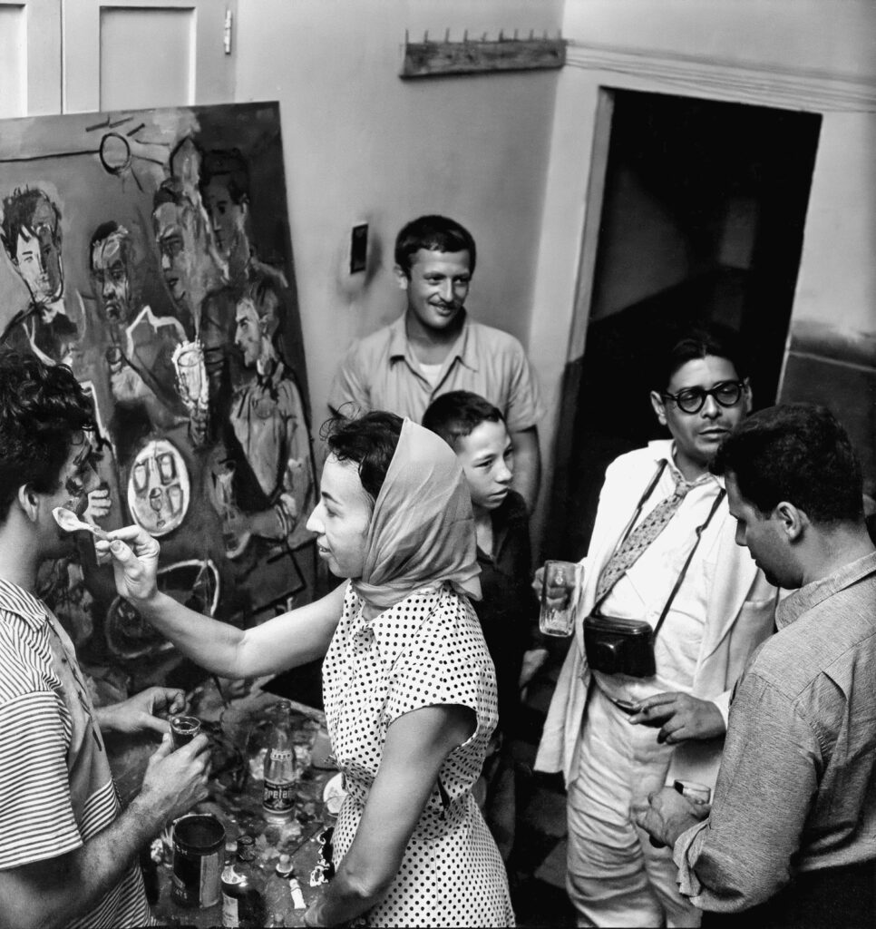 En 1955, en Barranquilla, Juan Antonio Roda retrató a cinco miembros de La Cueva: Alfonso Fuenmayor, Nereo López, Eduardo Vilá, Álvaro Cepeda Samudio y Alejandro Obregón. Con motivo de la instalación del cuadro en el bar, Cecilia Porras realizó un happening que fue fotografiado por Nereo López. Foto de la Biblioteca Nacional de Colombia.